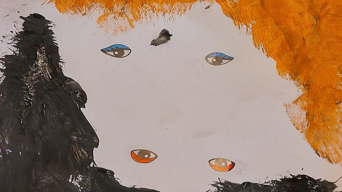 Familjen Hus - Öppna förskolan- konstverk med svart och orange färg med fyra ögon mitt på.