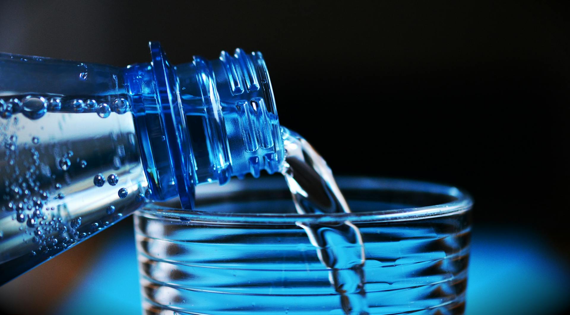 Vatten hälls i glas från flaska