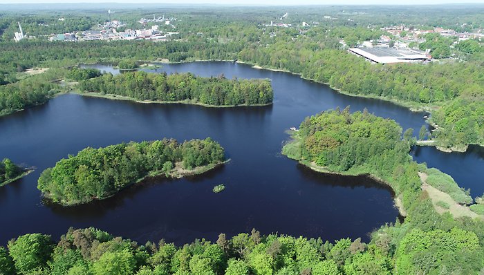Bild med drönarvy övber Ybbarpssjön med Perstorps Industripark i bakgrunden