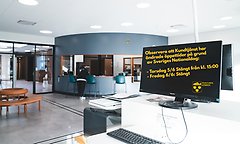 Interiör kundtjänst entré med text på en bildskärm om öppettider under Nationaldagen 2025